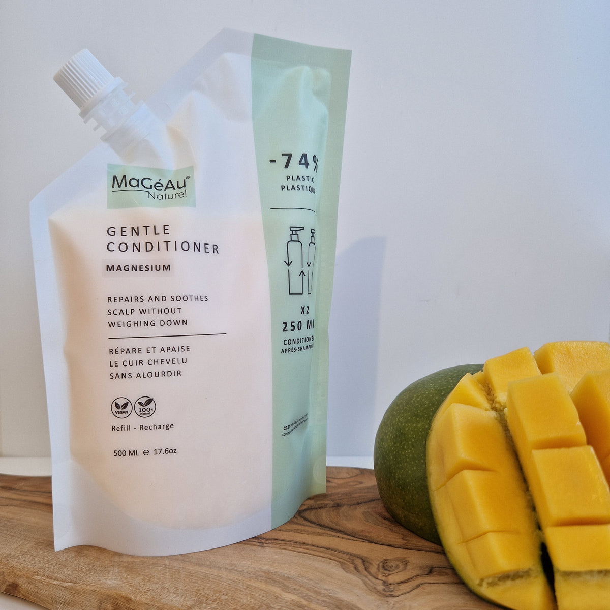 Mango and a bottle of Mageau naturel magnesium  Gentle Conditioner on a wooden surface