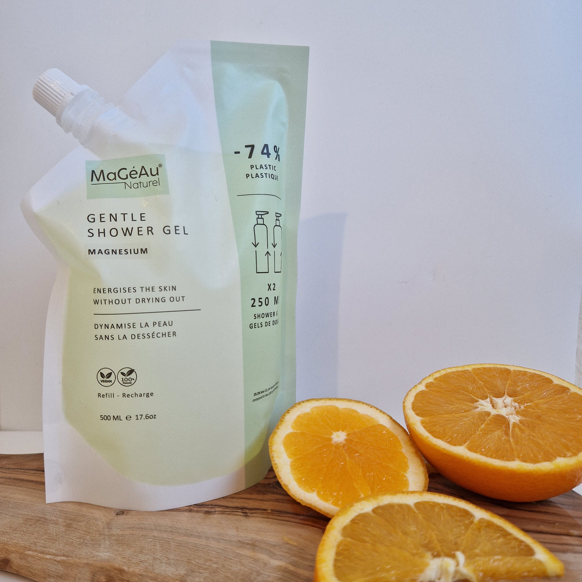 Mageau naturel magnesium shower gel tube with a cut orange on a wooden surface