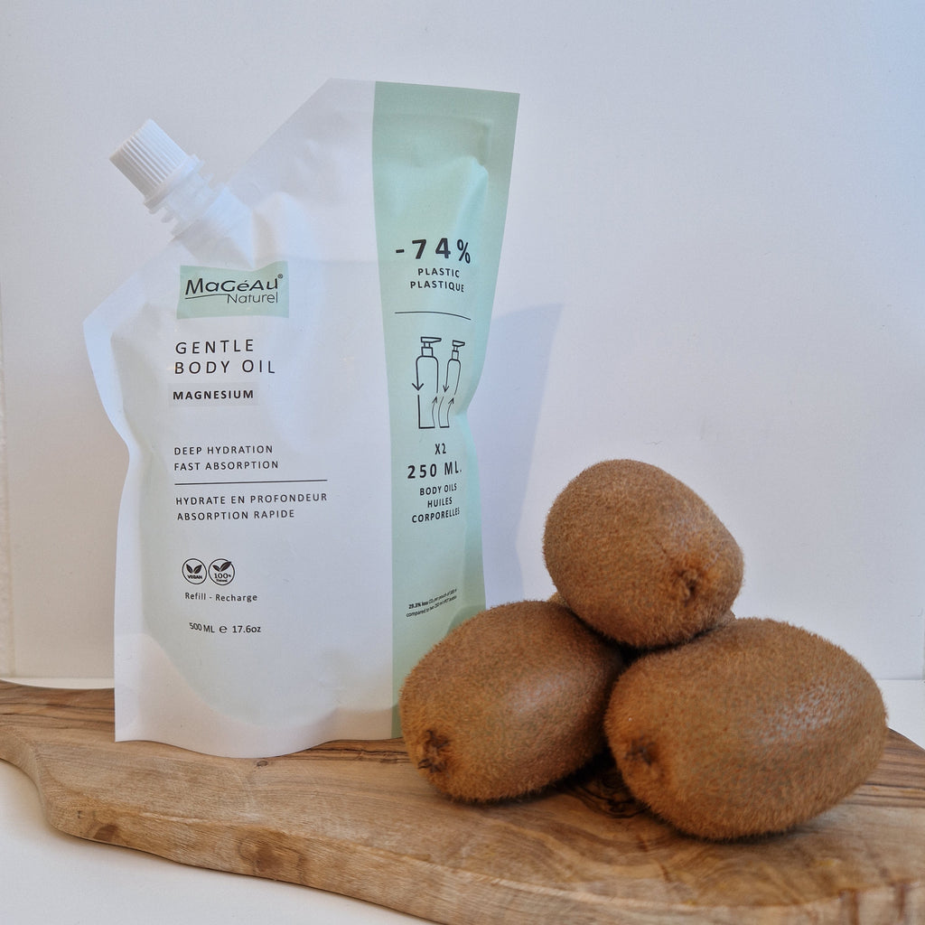 Tube of Mageau naturel magnesium Gentle Body Oil with kiwis on a wooden surface