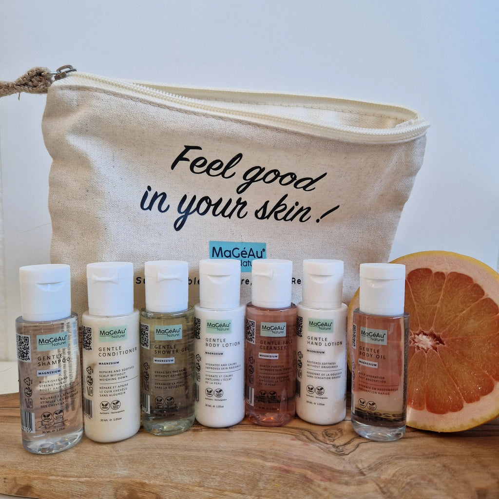 MaGéAu Naturel magnesium Cosmetic bag with 'Feel good in your skin!' text, containing skincare products on a wooden surface.