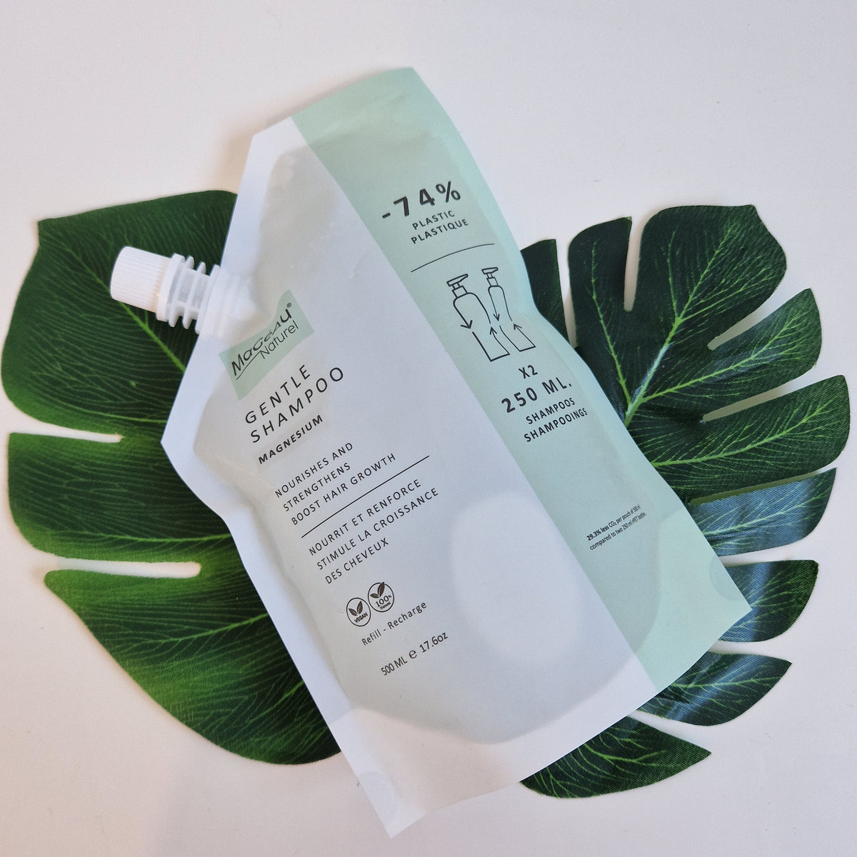 Mageau naturel magnesium shampoo bottles on a leaf with a white background