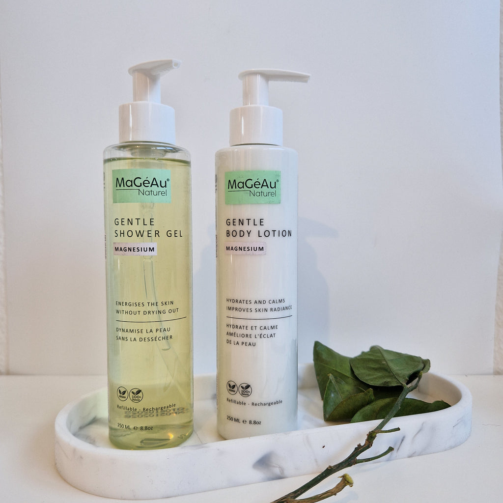 Two bottles of Mageau naturel magnesium body products on a white surface with a plant in the background.
